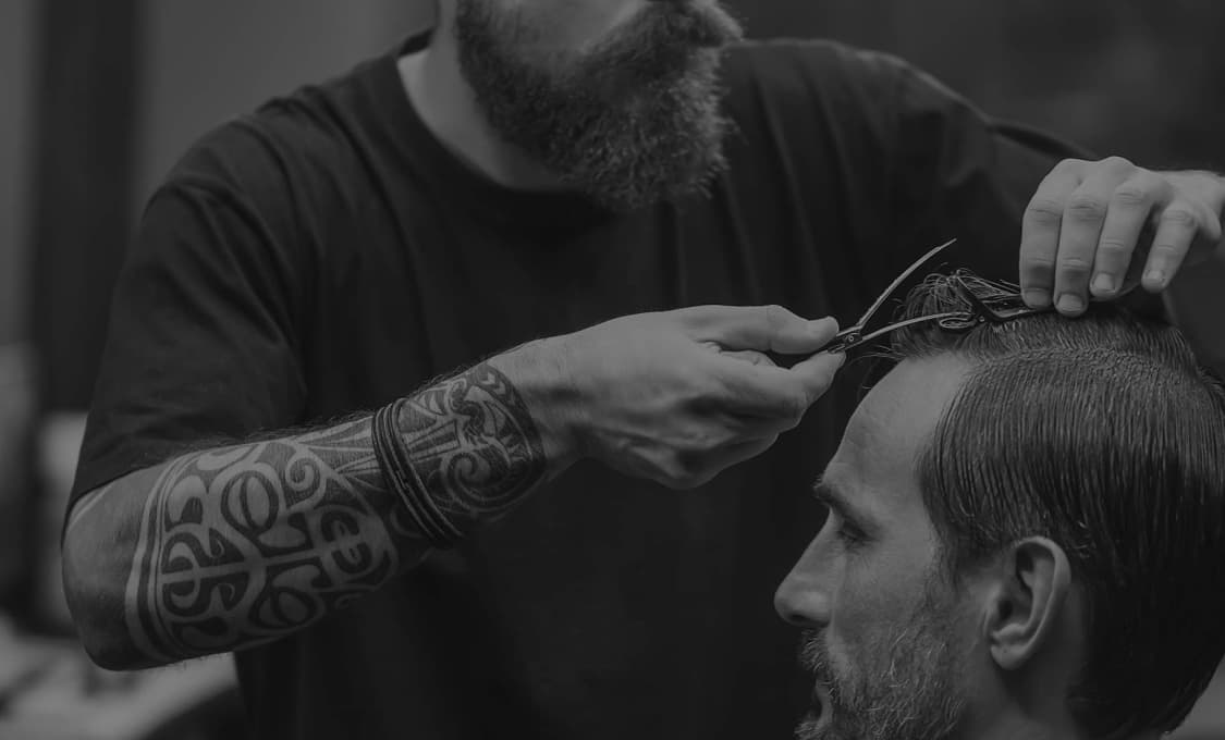 Бородатый барбер работает склиентом